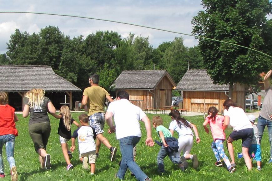 Kinder und Erwachsene, die auf einem Rasen rennen. 