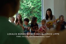 Kinder und Erzieherin machen Musik, Schriftzug "Lokales Bündnis für Familie Kreis Lippe"