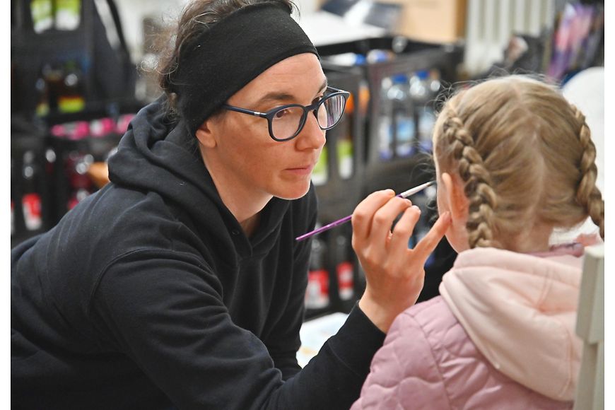 Eine Frau und ein Kind beim Kinderschminken