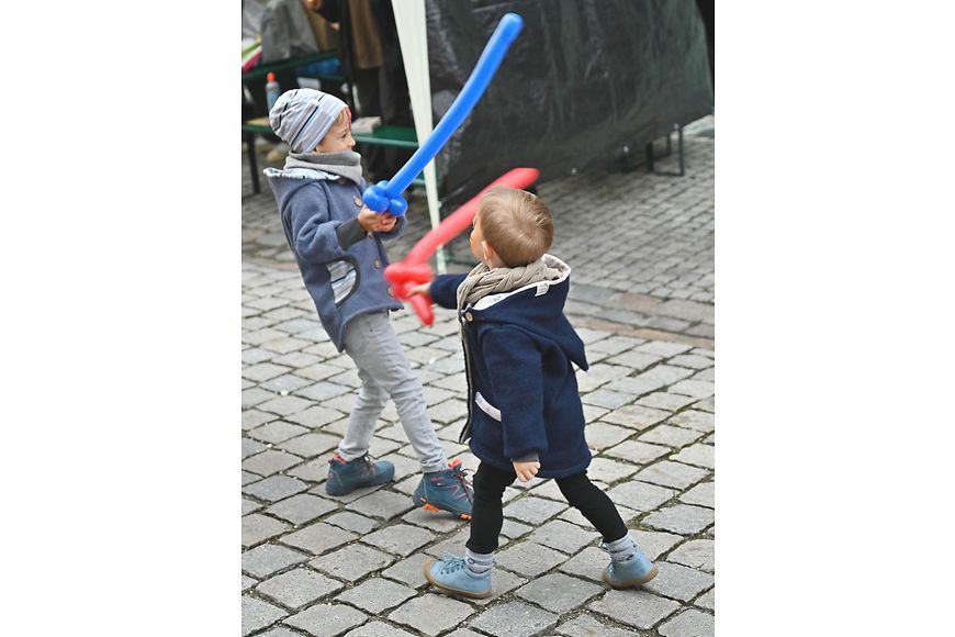 Zwei Kinder spielen mit Schwertern aus Luftballons