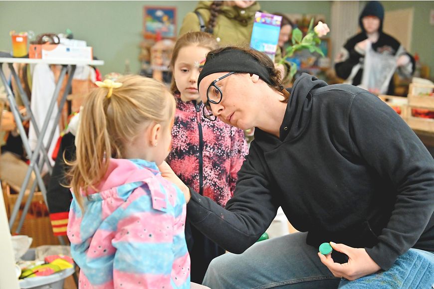 Eine Frau und zwei Mädchen beim Kinderschminken