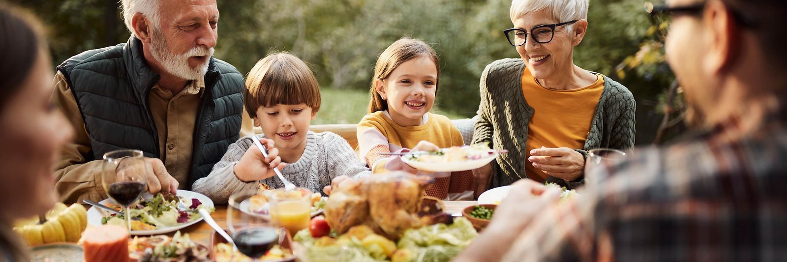 Mehrgenerationenfamilie beim Mittagessen in der Natur