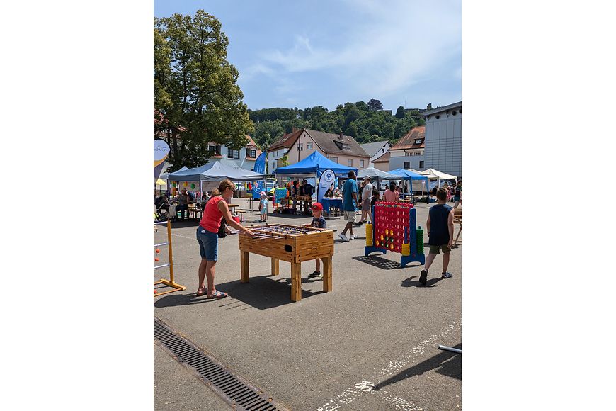 Eine Frau und ein Kind spielen Tischkicker auf einem Festplatz