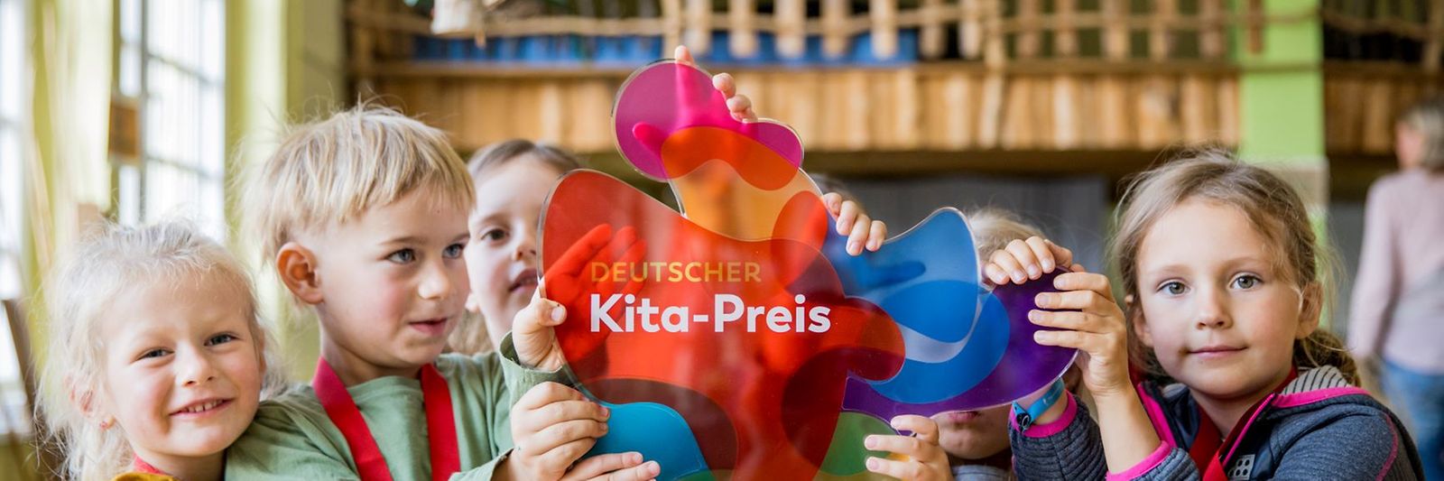 Eine Gruppe Kinder mit einer Trophäe des Deutschen Kita-Preis